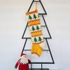Hand‑knitted Christmas stocking with festive green tree design on red and cream background