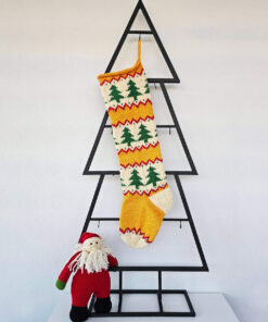 Hand‑knitted Christmas stocking with festive green tree design on red and cream background