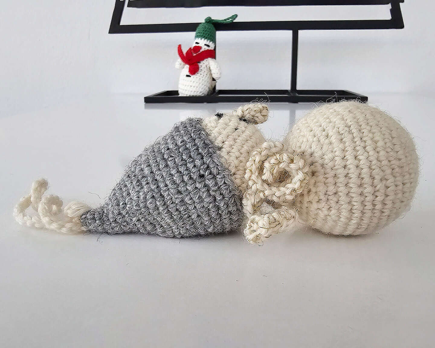 Crochet snowman Christmas tree decoration with gray beanie, cream torso, smiling expression