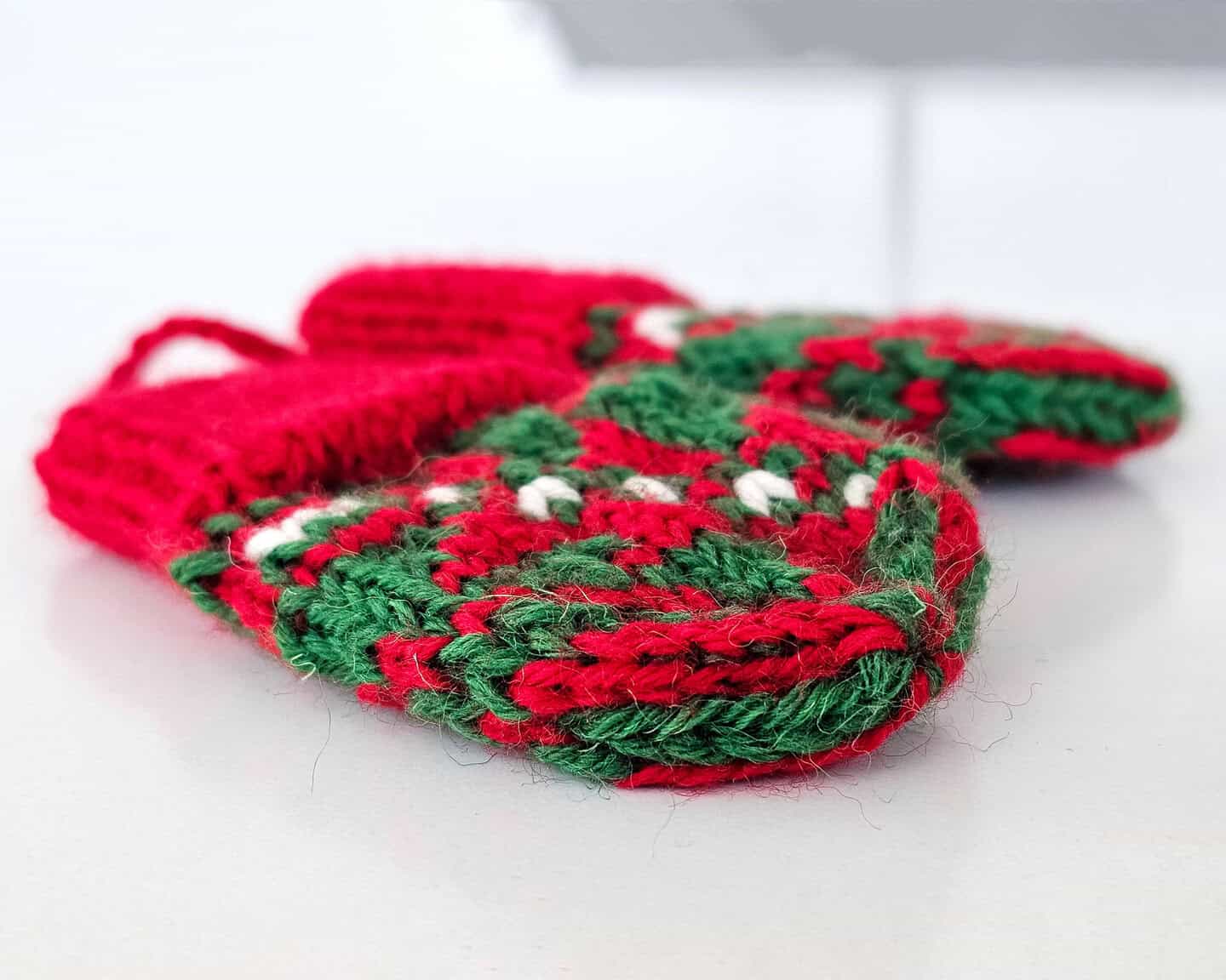 Charming hand-knit mini mitten ornaments in red and green