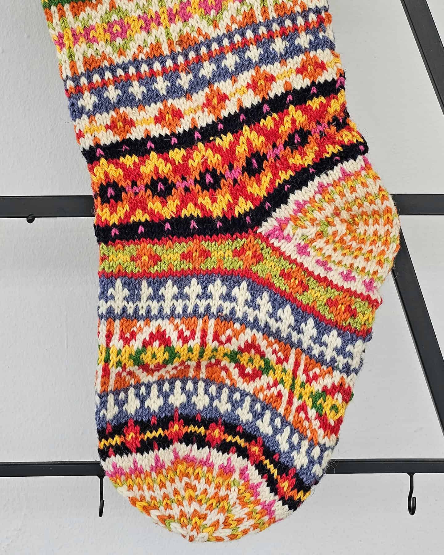 Knit Christmas stocking in red, green, and yellow stripes