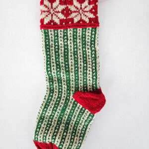 Hand-knit Christmas stocking with green and white stripes and red snowflake cuff