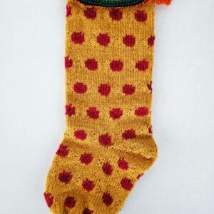 Hand-knit fair-trade Christmas tree stocking in mustard yellow with red polka dot pattern