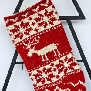 Handmade holiday stocking with red background and cream reindeer