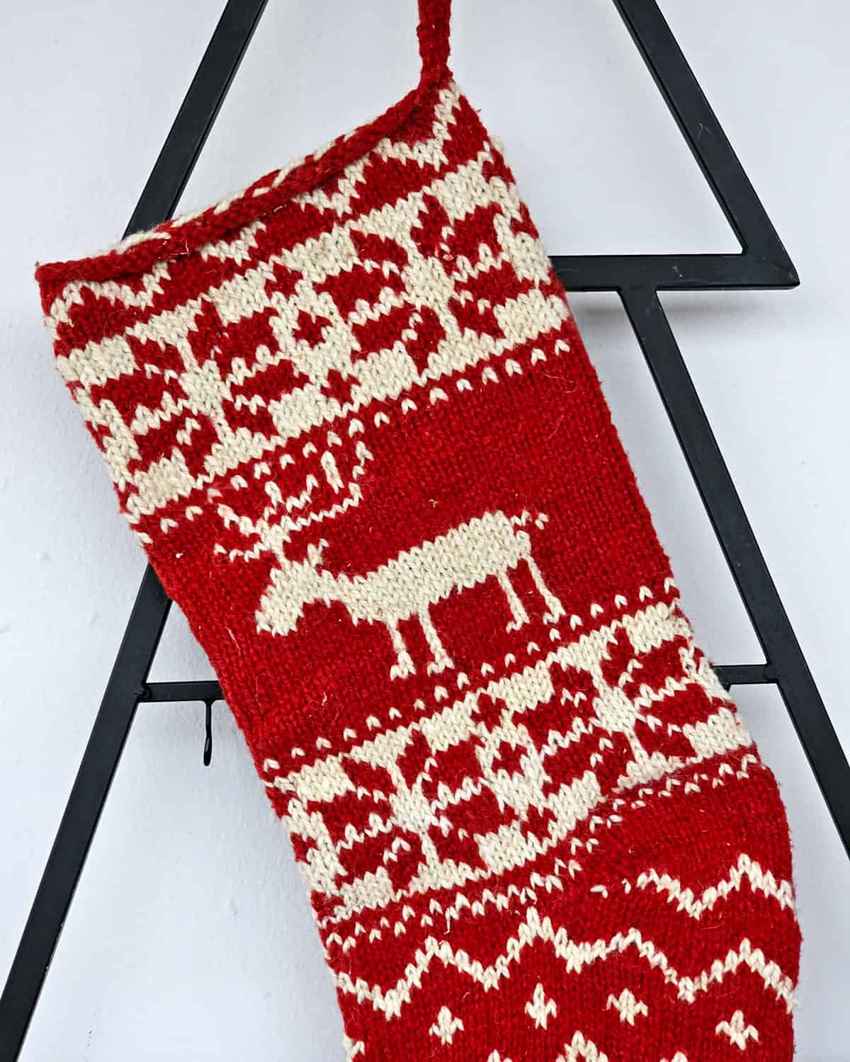 Handmade holiday stocking with red background and cream reindeer