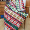 Handmade crocheted Christmas blanket with festive snowflake, reindeer, and tree patterns