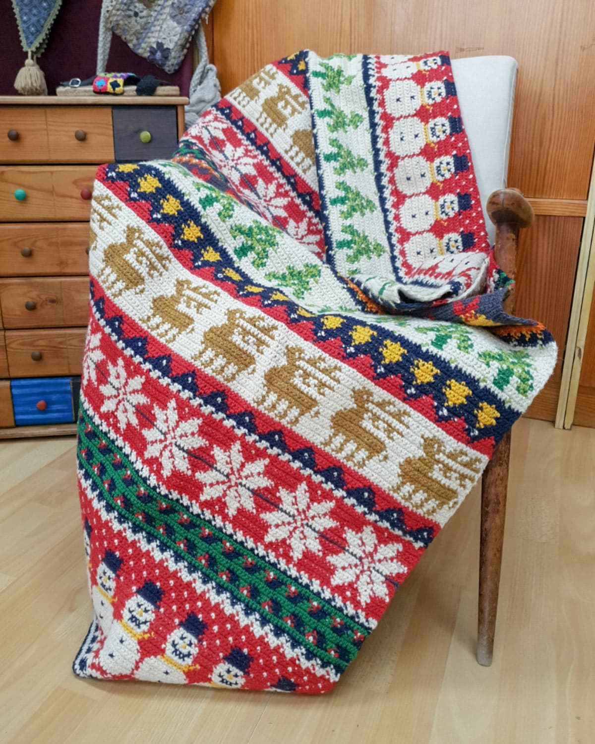 Handmade crocheted Christmas blanket with festive snowflake, reindeer, and tree patterns
