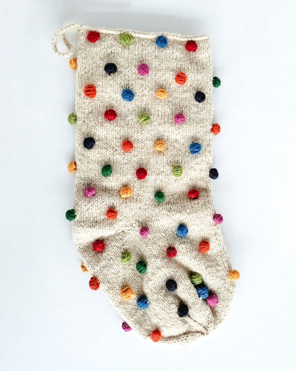 Artisan Christmas stocking decorated with colorful pom-poms
