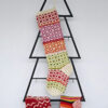 Hand-knit Christmas tree stocking with red, green, orange, and purple patterns