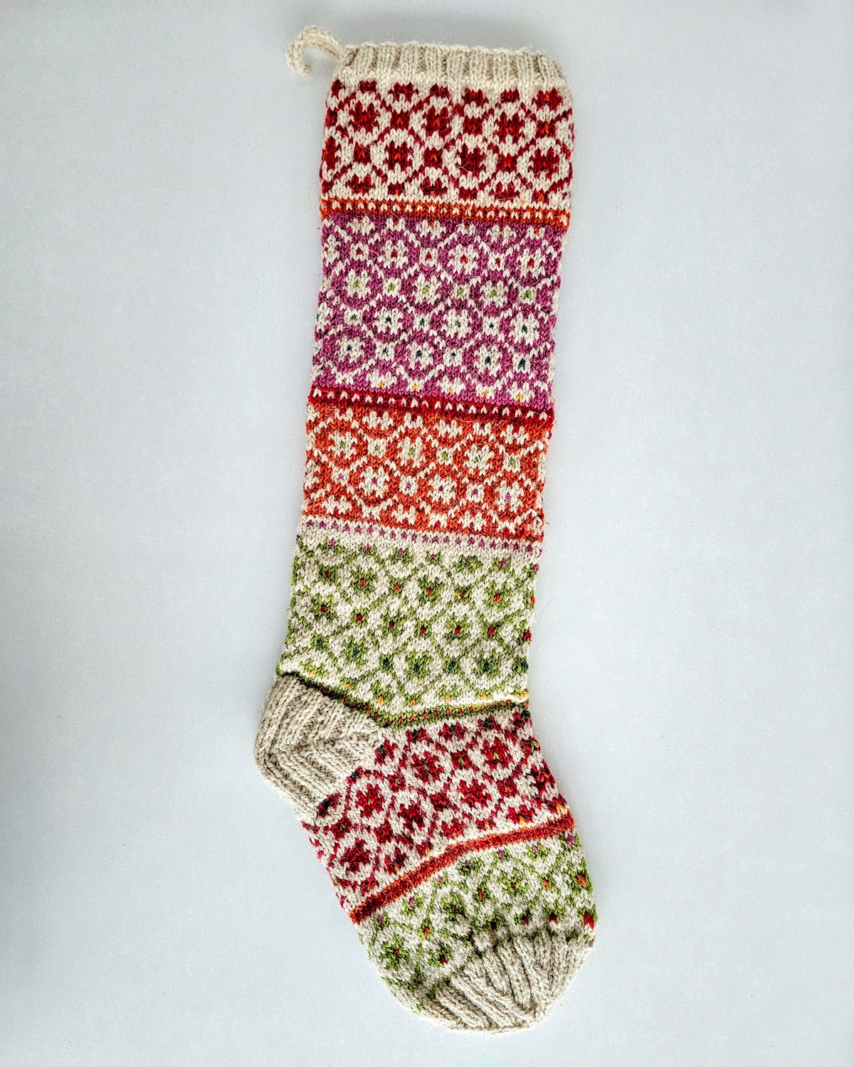 Artisan Christmas tree stocking featuring multicolor festive motifs
