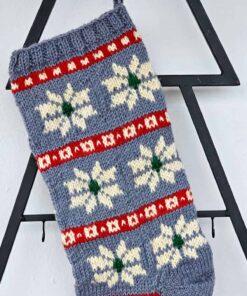 Handmade knitted Christmas stocking with snowflakes in blue, red, and white