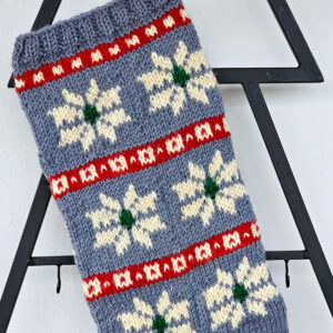 Handmade knitted Christmas stocking with snowflakes in blue, red, and white