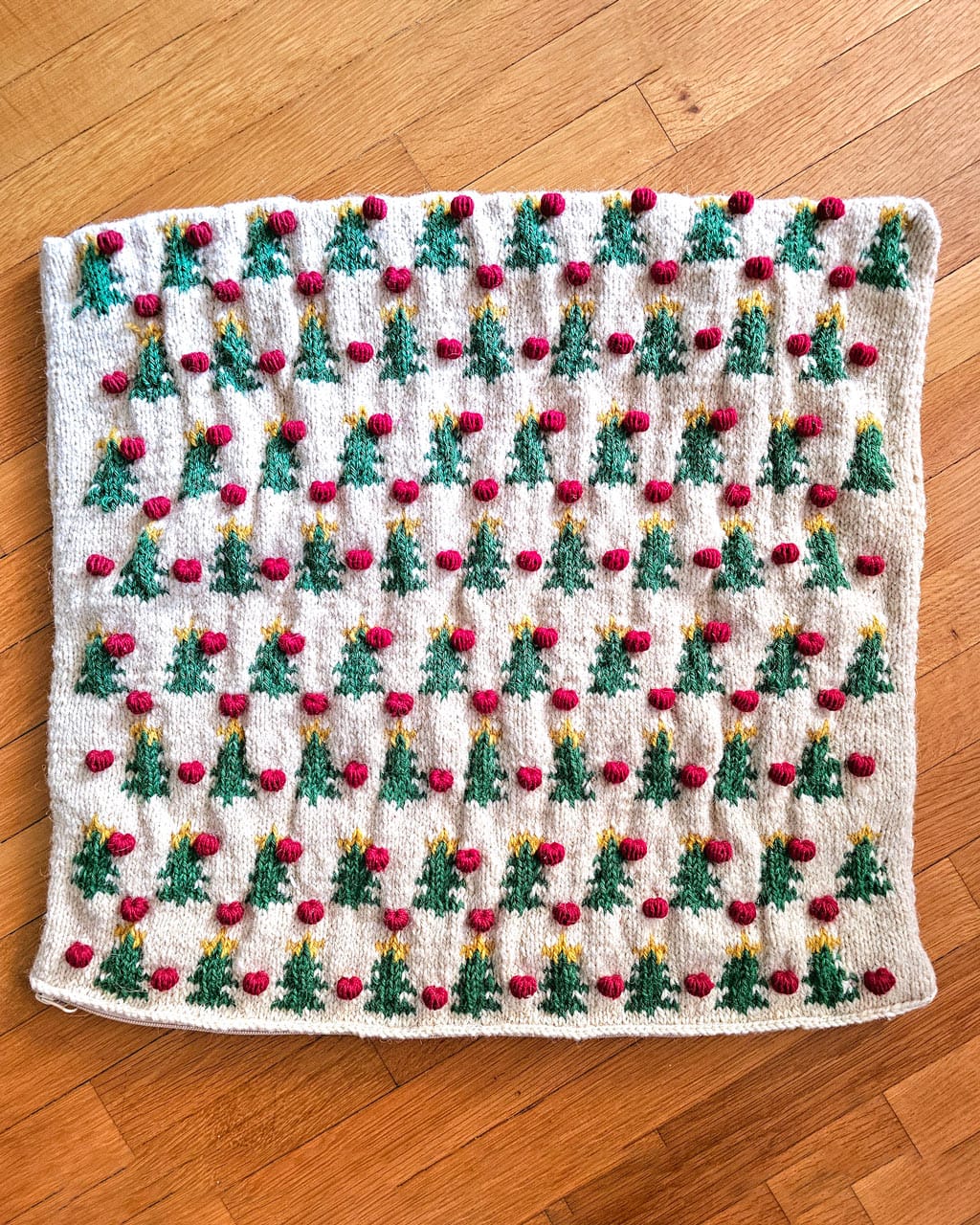 Handmade Christmas pillow flat lay with ornaments and pine branches
