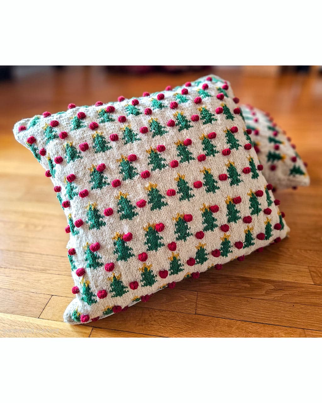 Handmade Christmas pillow cover with festive design on wooden floor