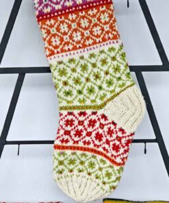 Handmade stocking with decorative patterns in cream and bright colors