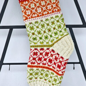 Handmade stocking with decorative patterns in cream and bright colors