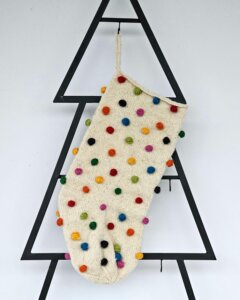 Hand-knit holiday stocking with multicolor pom-poms. Limited edition Christmas tree stocking