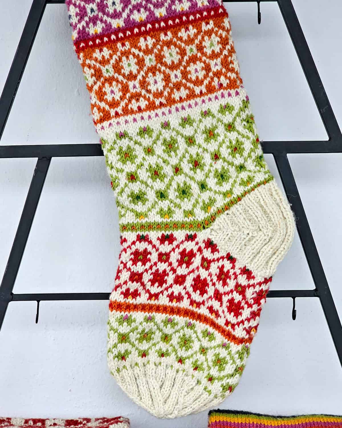 Handmade stocking with decorative patterns in cream and bright colors