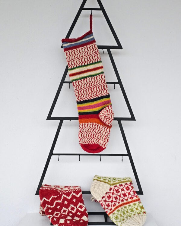 Hand-knit Christmas tree stocking with red and white knit and colorful stripes