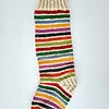 Festive holiday stocking in red, green, white stripes with tree design