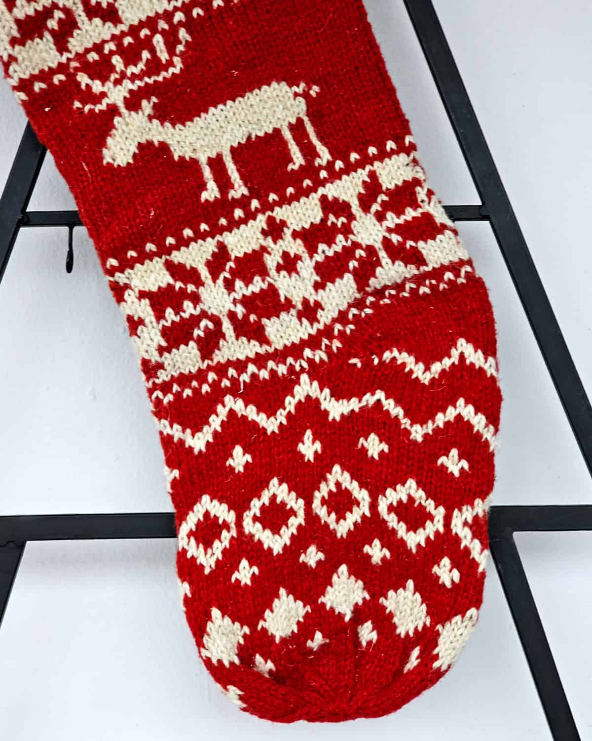 Festive knit stocking featuring reindeer and snowflake holiday designs