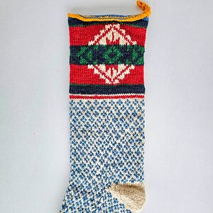 Hand-knitted BHcrafts Christmas stocking with traditional Bosnian folk pattern, featuring a blue and cream diamond body and a multi-colored geometric cuff.