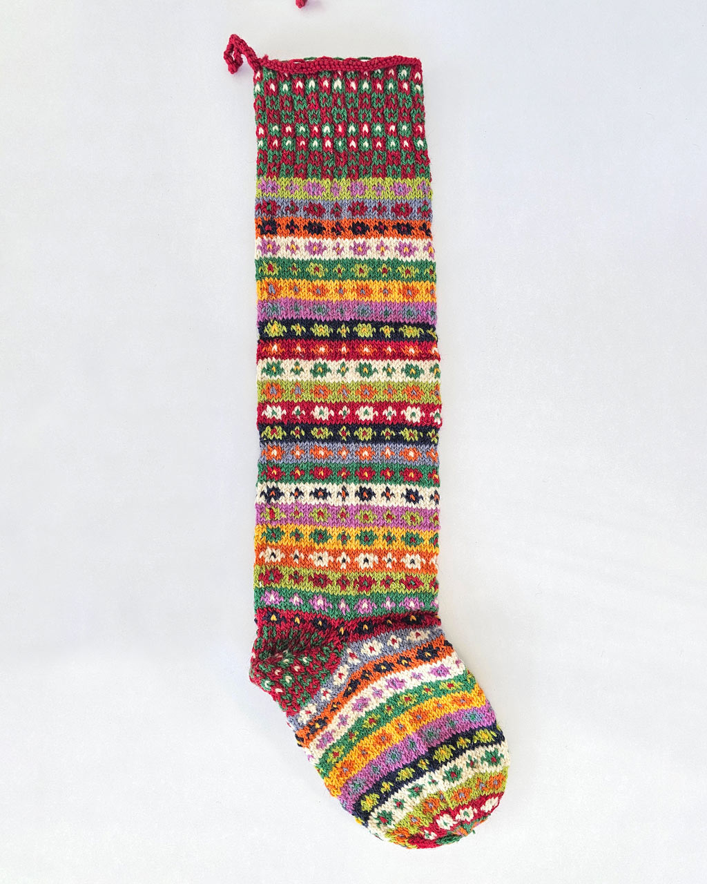 Knitted Christmas tree stocking in red, green, and multicolor patterns