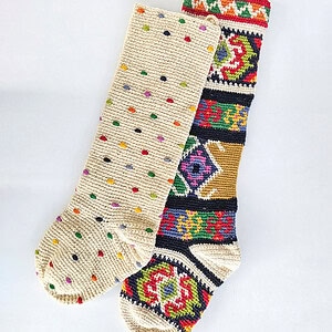 Set of two handmade crochet Christmas stockings featuring multicolored polka dots and a vibrant tapestry-style woven pattern.