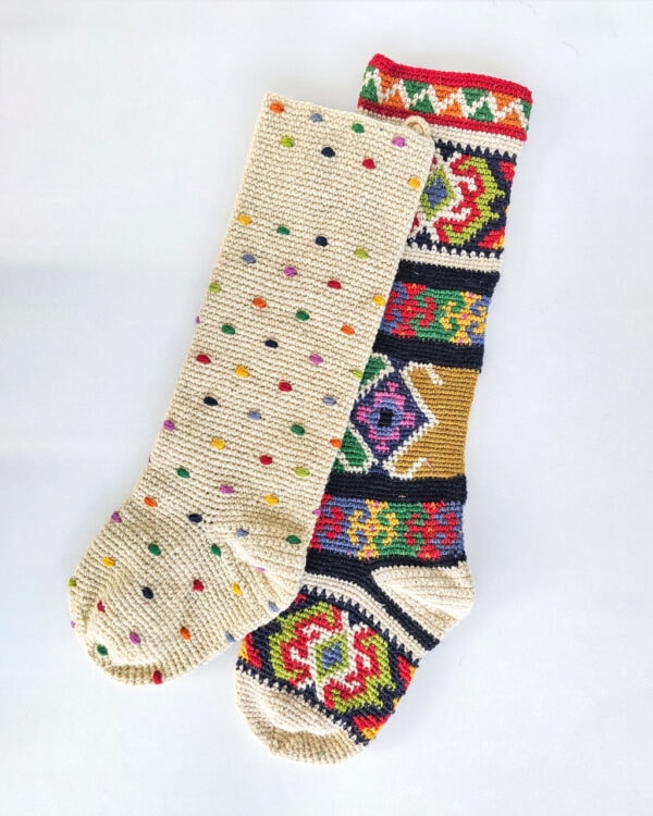 Set of two handmade crochet Christmas stockings featuring multicolored polka dots and a vibrant tapestry-style woven pattern.