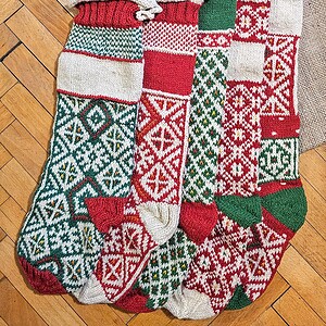 Five colorful knitted Christmas stockings with various pattern.