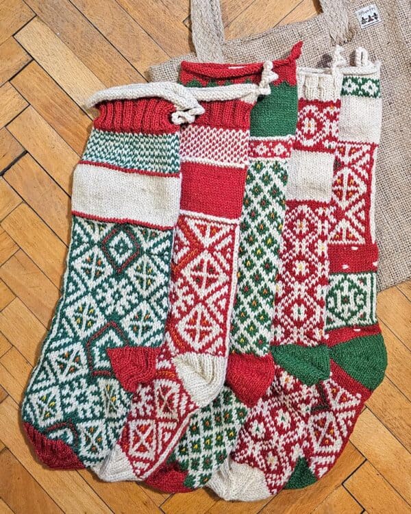 Five colorful knitted Christmas stockings with various pattern.
