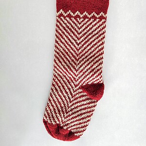 Fair trade artisanal Christmas stocking in red and cream zigzag knit design.