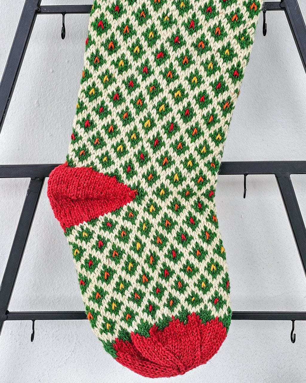 Green and red hand knit personalized holiday stockings with diamond lattice and scalloped cuff, artisan made.