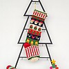 Fair-trade Christmas stocking featuring Santa, gifts, and bells in multicolor design.