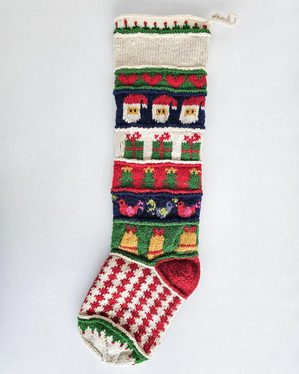 Full view of a personalized Christmas stocking hand-knitted with festive motifs.