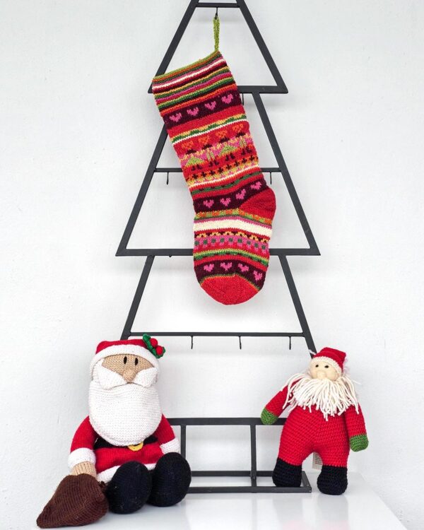 Hand knit Christmas stocking with colorful stripes and heart motifs, artisan made