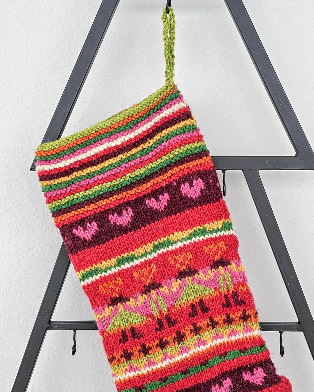 Handmade knitted Christmas stocking with colorful Hearts and Stripes