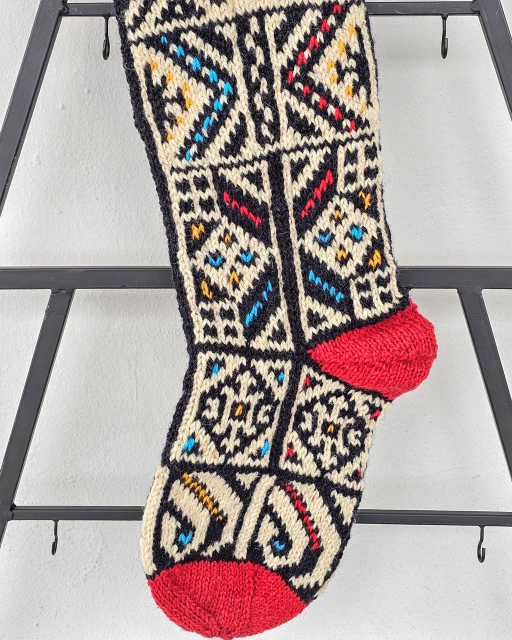 Close-up of red heel on personalized Christmas stocking with jacquard pattern.