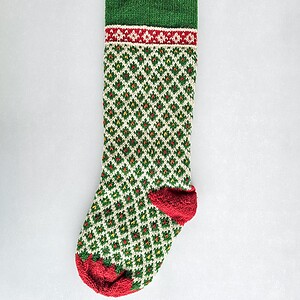 Personalized green knit Christmas stocking with red cuff and white diamond pattern, custom name on the cuff