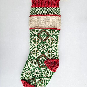 Personalized hand-knitted Christmas stocking featuring traditional Bosnian weave patterns in red, green, and cream, with a customizable embroidered name.