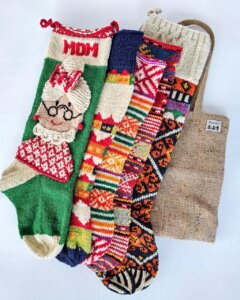 Five knitted Christmas stockings with various patterns.