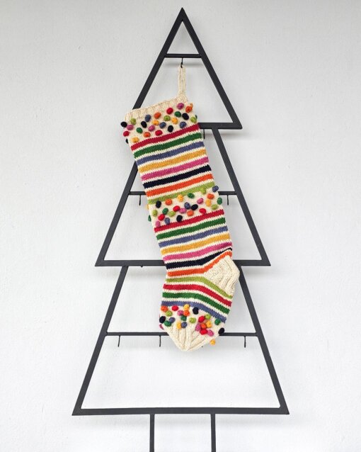 Handmade holiday stocking with stripes and colorful pom-poms